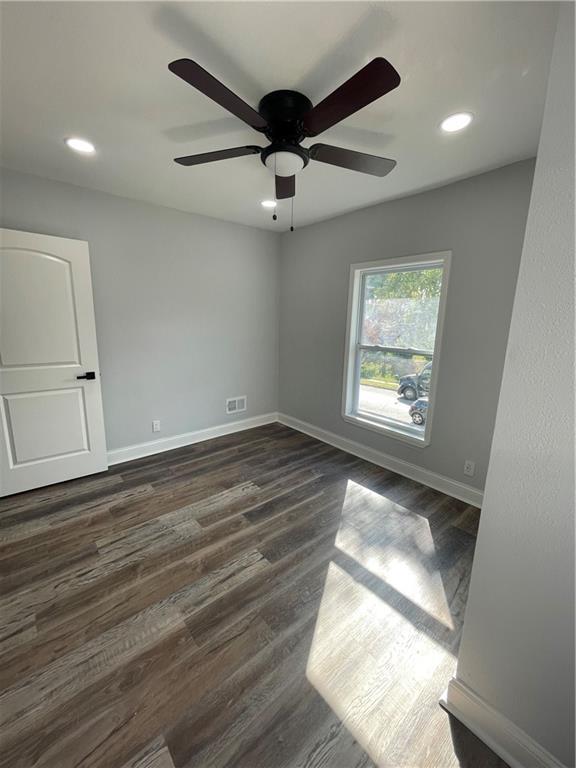 empty room featuring ceiling fan and dark hardwood / wood-style flooring