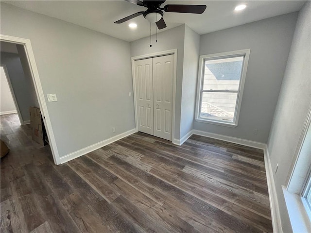 unfurnished bedroom with ceiling fan, dark hardwood / wood-style floors, and a closet