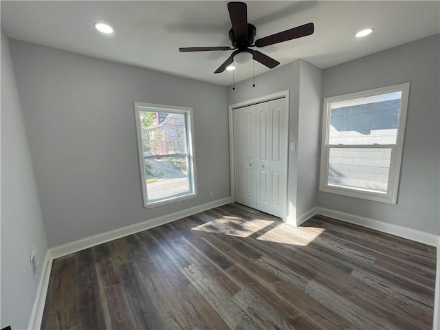 unfurnished bedroom with dark hardwood / wood-style flooring, a closet, and ceiling fan