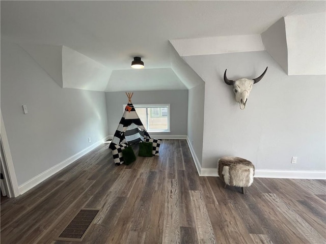 additional living space featuring dark hardwood / wood-style floors and lofted ceiling