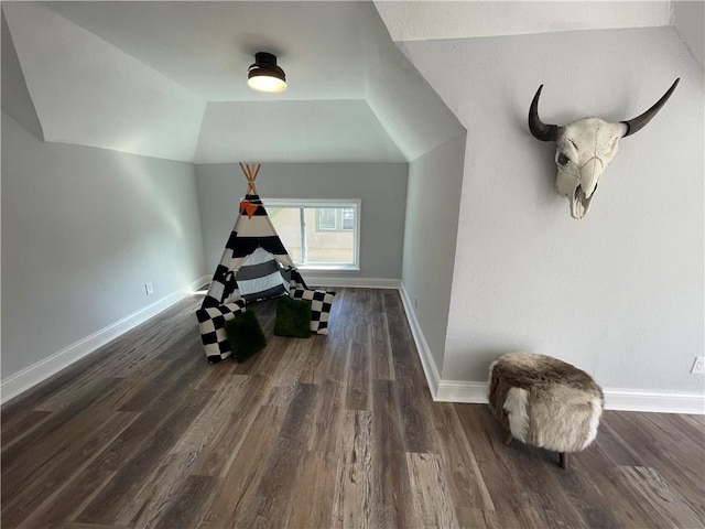 workout room with lofted ceiling and dark wood-type flooring