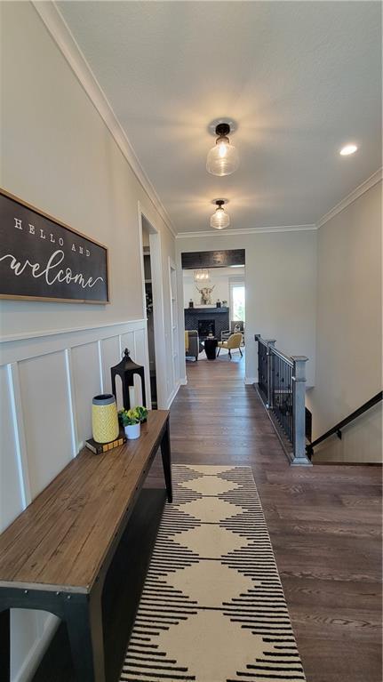 hall with crown molding and dark wood-type flooring