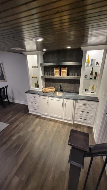 bar with white cabinets, built in shelves, wooden ceiling, and dark wood-type flooring