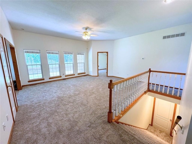 interior space with carpet flooring and ceiling fan