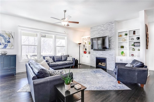 living room featuring ceiling fan, a fireplace, and dark hardwood / wood-style flooring