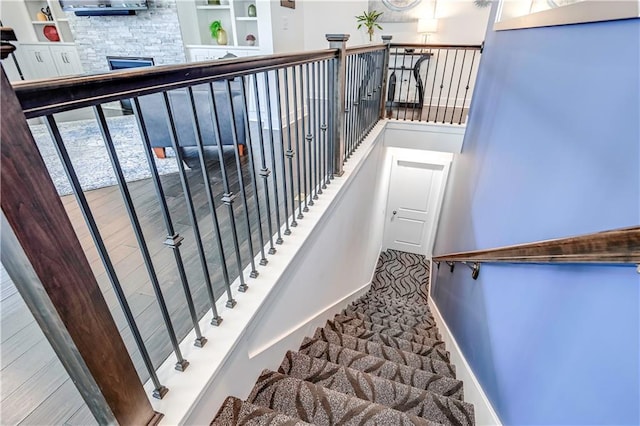 stairway with a stone fireplace