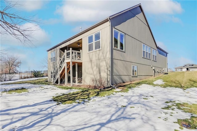 snow covered rear of property with ceiling fan