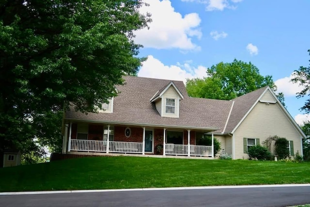 cape cod house featuring a porch and a front yard