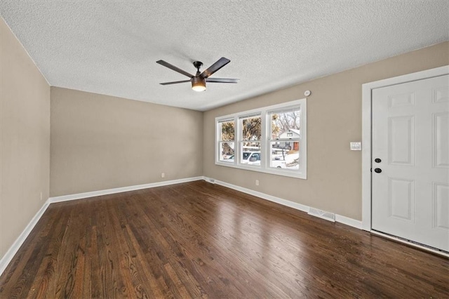 interior space featuring a textured ceiling, ceiling fan, and dark wood-type flooring