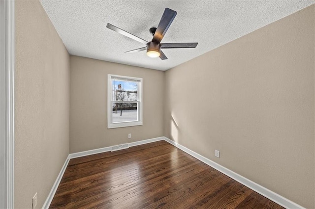 empty room with a textured ceiling, dark hardwood / wood-style floors, and ceiling fan