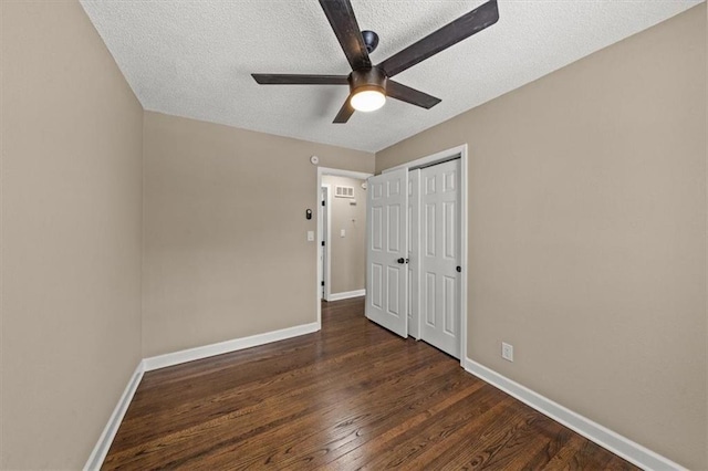 unfurnished bedroom with ceiling fan, dark wood-type flooring, and a textured ceiling