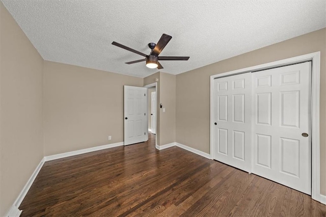 unfurnished bedroom with dark hardwood / wood-style flooring, ceiling fan, a closet, and a textured ceiling