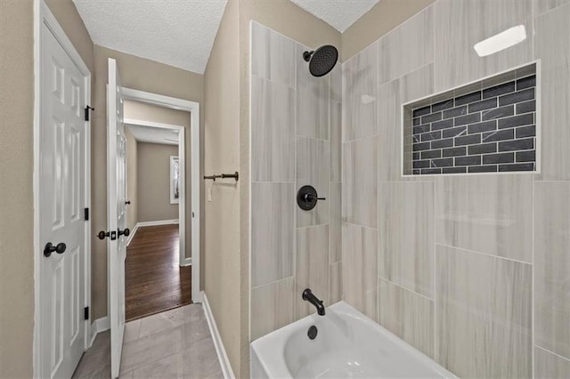 bathroom featuring a textured ceiling, tile patterned floors, and tiled shower / bath combo