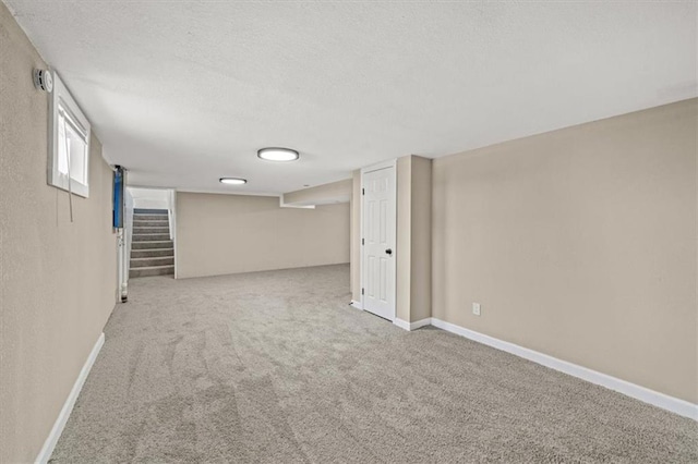 basement with light colored carpet and a textured ceiling