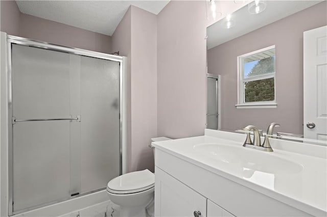 bathroom featuring vanity, walk in shower, toilet, and a textured ceiling