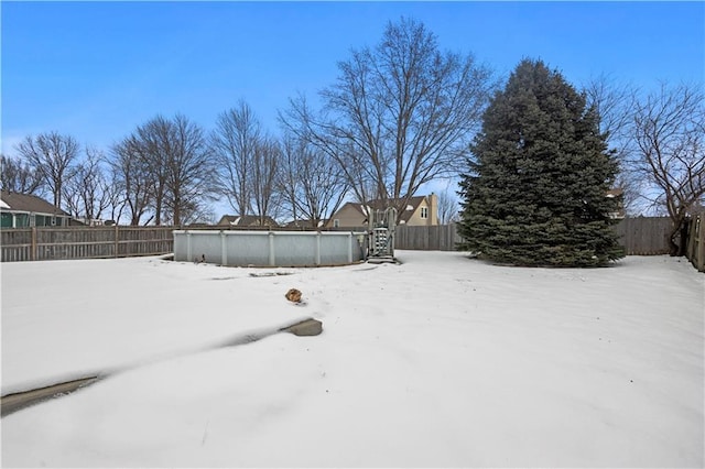 yard layered in snow with a fenced in pool