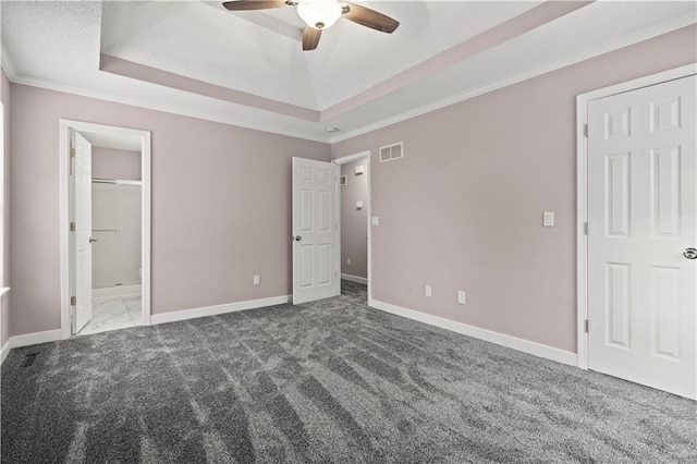 unfurnished bedroom with ceiling fan, ornamental molding, a raised ceiling, and carpet