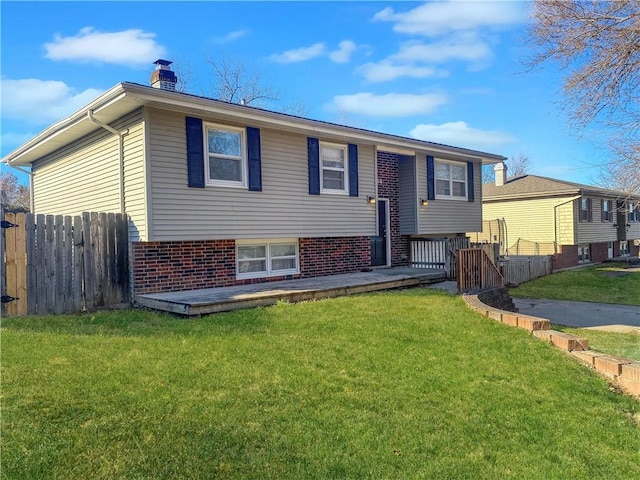 bi-level home featuring a deck and a front lawn