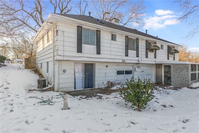 view of front of house featuring a garage and central AC