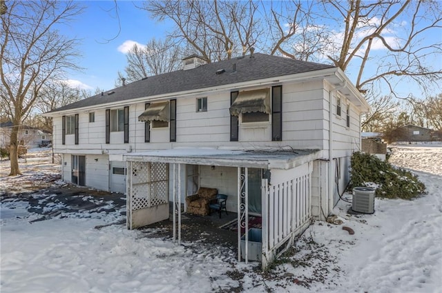 view of front of property featuring a garage and cooling unit