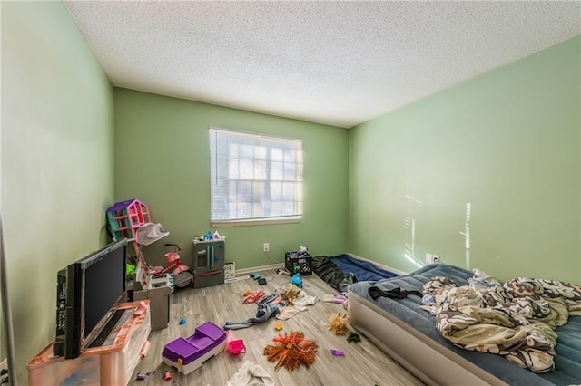 bedroom featuring a textured ceiling and hardwood / wood-style flooring