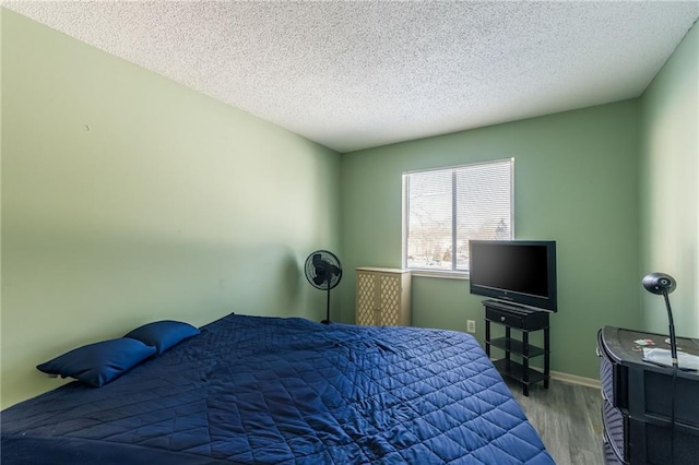 bedroom with a textured ceiling and hardwood / wood-style floors