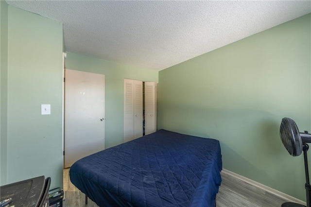 bedroom featuring a textured ceiling and light hardwood / wood-style flooring