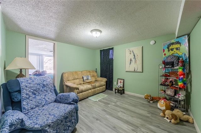 living room with a textured ceiling and light wood-type flooring