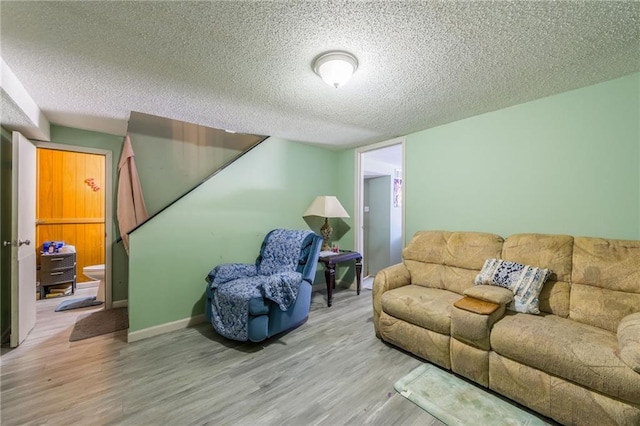 living room with a textured ceiling and light hardwood / wood-style flooring