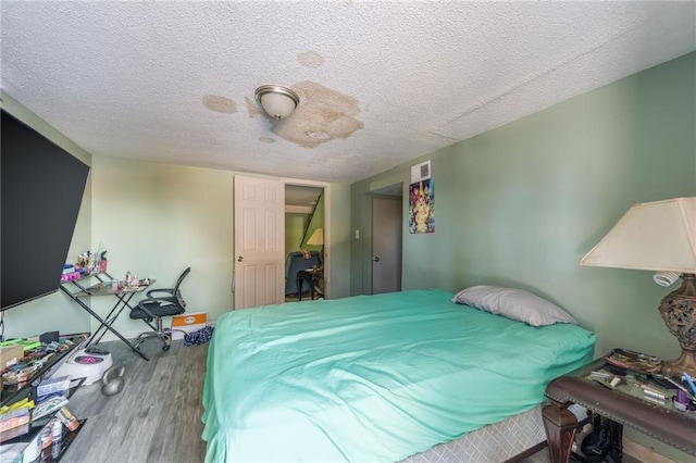 bedroom with a textured ceiling and hardwood / wood-style flooring