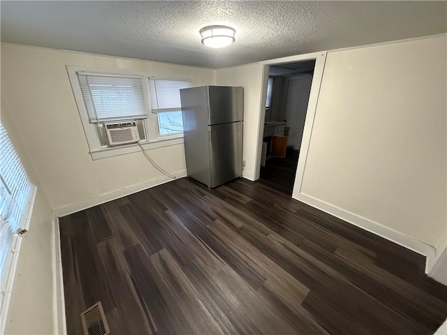 interior space featuring stainless steel fridge, a textured ceiling, cooling unit, dark hardwood / wood-style floors, and a closet