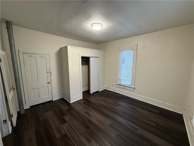 unfurnished bedroom with dark hardwood / wood-style floors and a textured ceiling