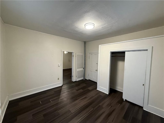 unfurnished bedroom with a closet, dark wood-type flooring, and a textured ceiling