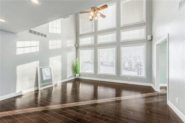 interior space featuring a towering ceiling and ceiling fan