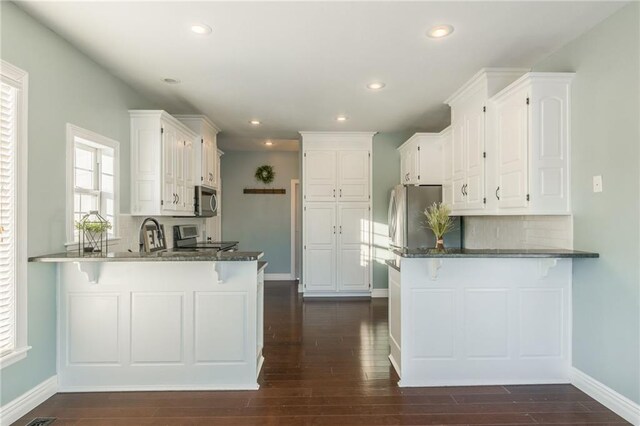 kitchen with kitchen peninsula, white cabinets, and stainless steel appliances