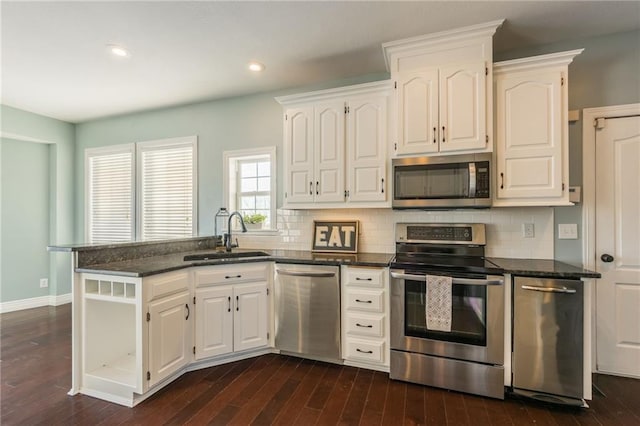 kitchen featuring sink, white cabinets, tasteful backsplash, dark hardwood / wood-style flooring, and appliances with stainless steel finishes