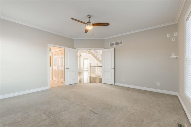 unfurnished bedroom featuring ceiling fan, light carpet, and crown molding