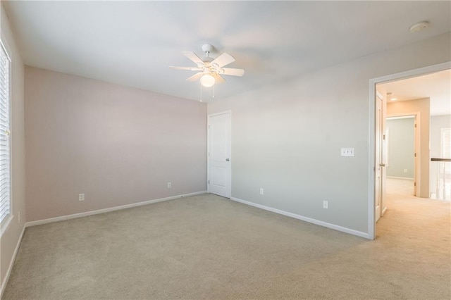 spare room with light colored carpet and ceiling fan