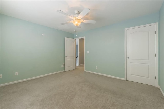 unfurnished room featuring light carpet and ceiling fan