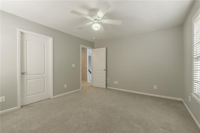 unfurnished bedroom with ceiling fan, light colored carpet, and multiple windows