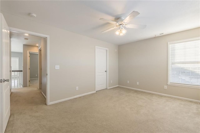 carpeted spare room with ceiling fan