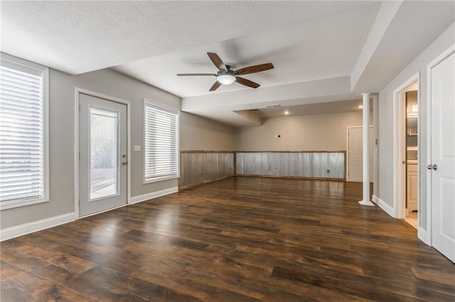 unfurnished room with a textured ceiling, ceiling fan, and dark wood-type flooring