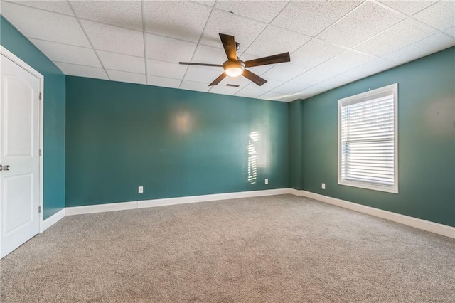 carpeted empty room featuring a drop ceiling and ceiling fan