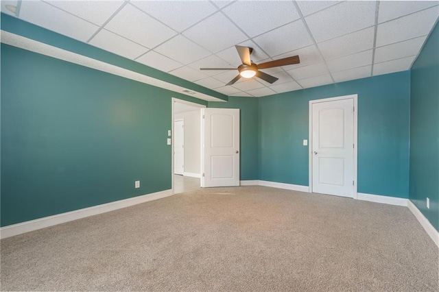 carpeted spare room with a paneled ceiling and ceiling fan