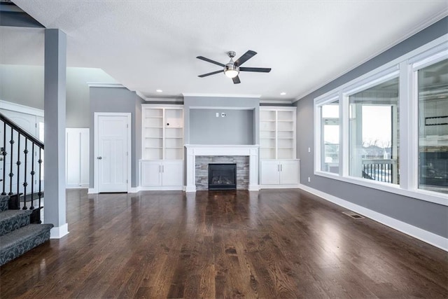 unfurnished living room with ceiling fan, built in shelves, dark hardwood / wood-style flooring, and a fireplace