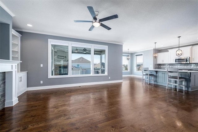 unfurnished living room with ceiling fan, a textured ceiling, dark hardwood / wood-style floors, and ornamental molding