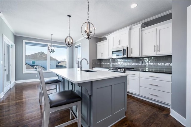 kitchen with decorative light fixtures, sink, white cabinetry, and tasteful backsplash