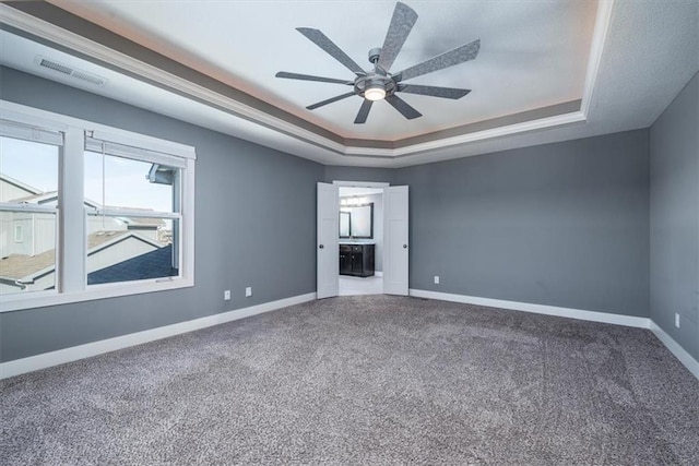 carpeted empty room featuring ceiling fan and a tray ceiling