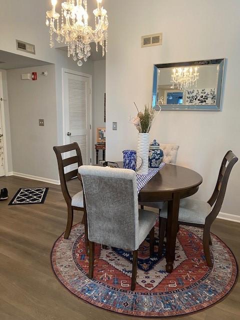 dining room with hardwood / wood-style floors and an inviting chandelier