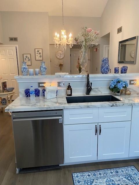 kitchen with dishwasher, white cabinets, hanging light fixtures, and sink